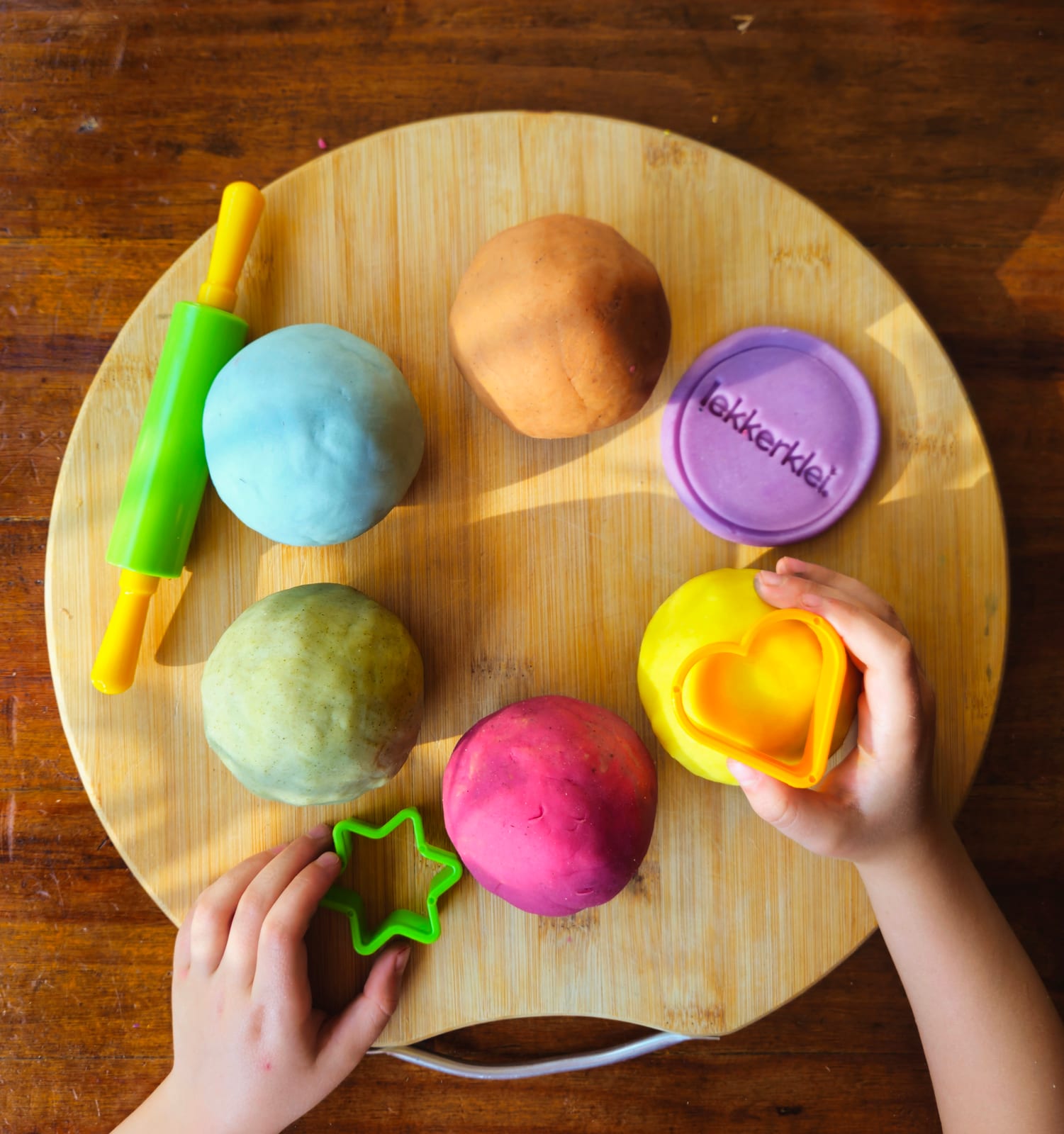 Colourful lekkerklei playdough balls on a wooden surface